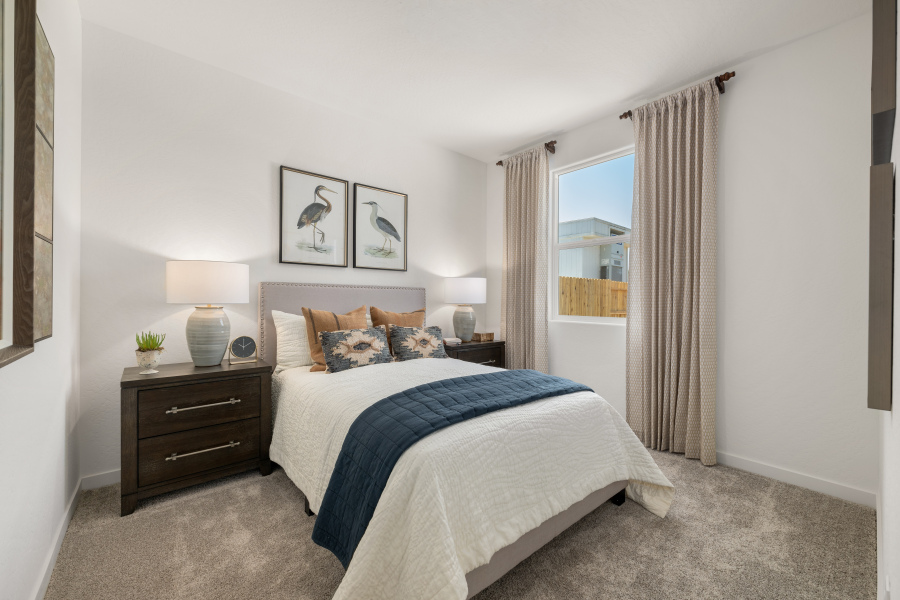 A bedroom with a bed and lamps.