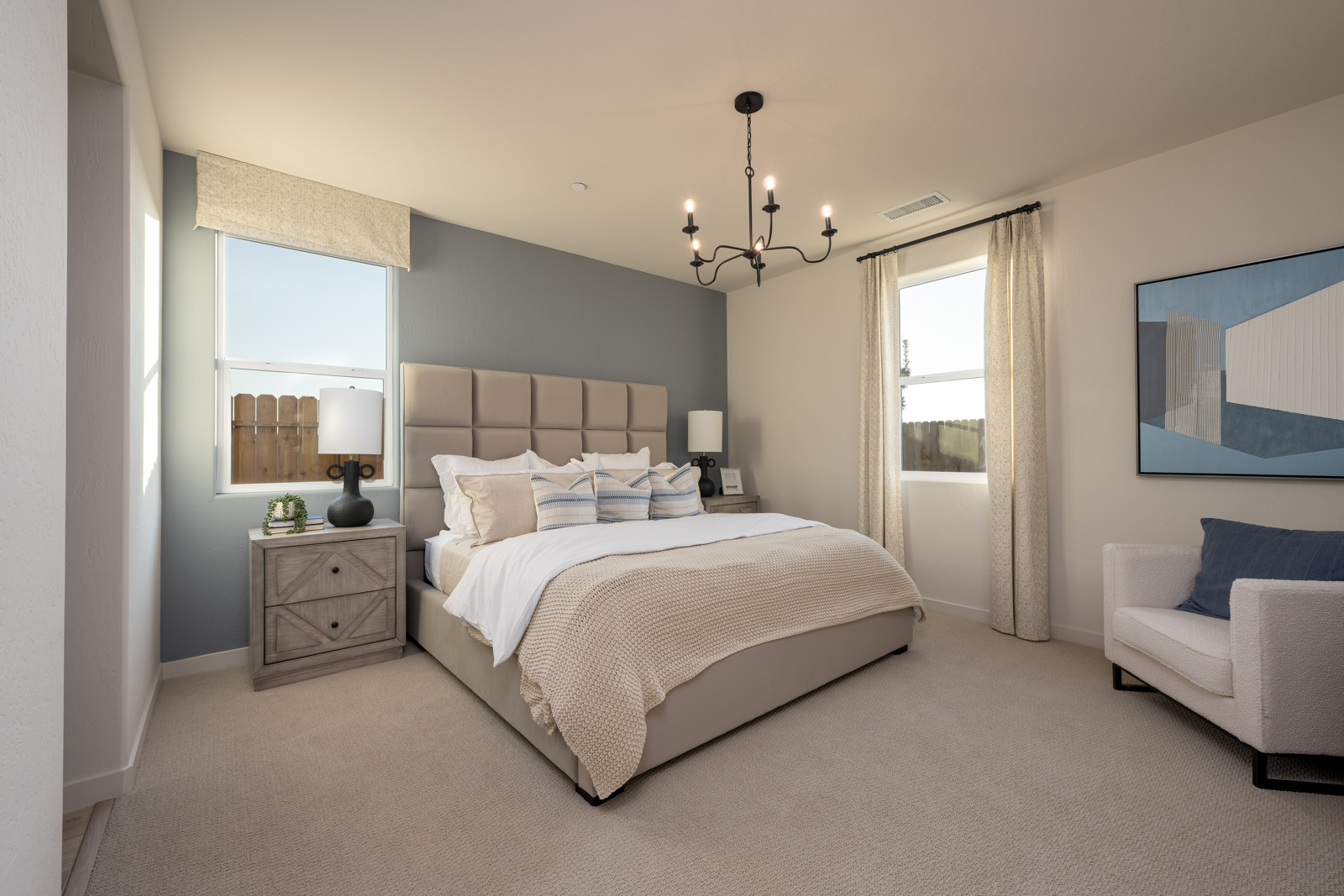 A bedroom with a bed and a chair.