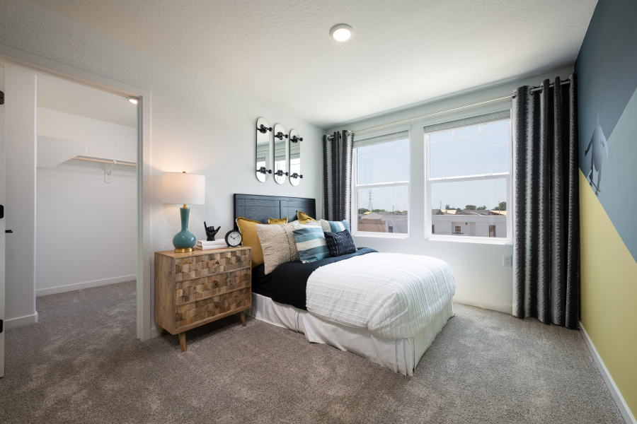 A bedroom with a bed and a mirror.