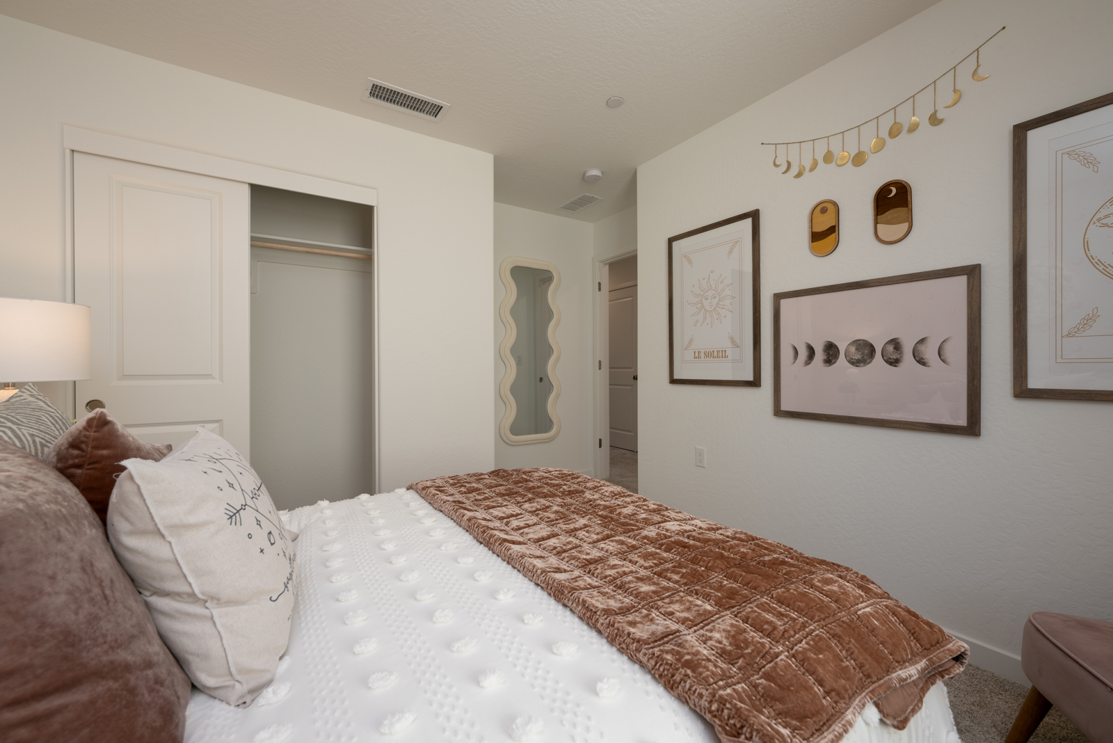 A bedroom with a bed and a lamp.