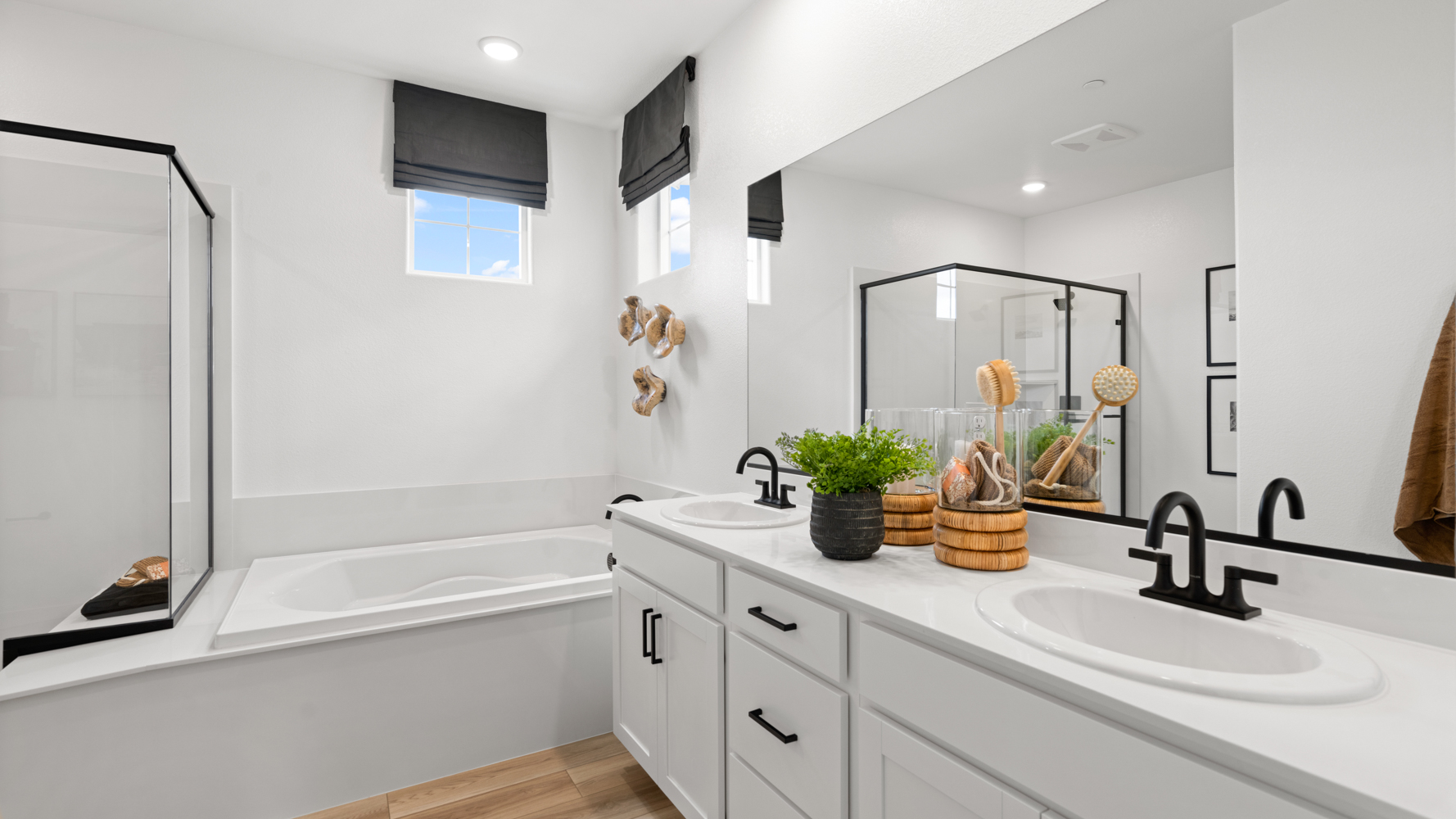 A bathroom with a tub sink and mirror.