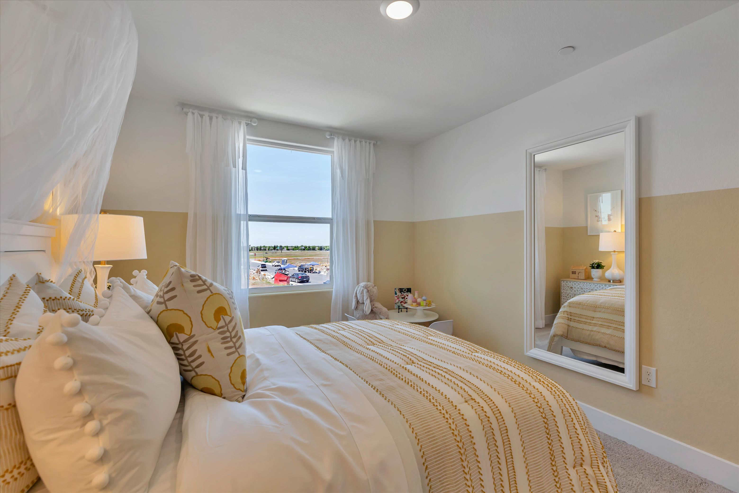 A bedroom with a large mirror.