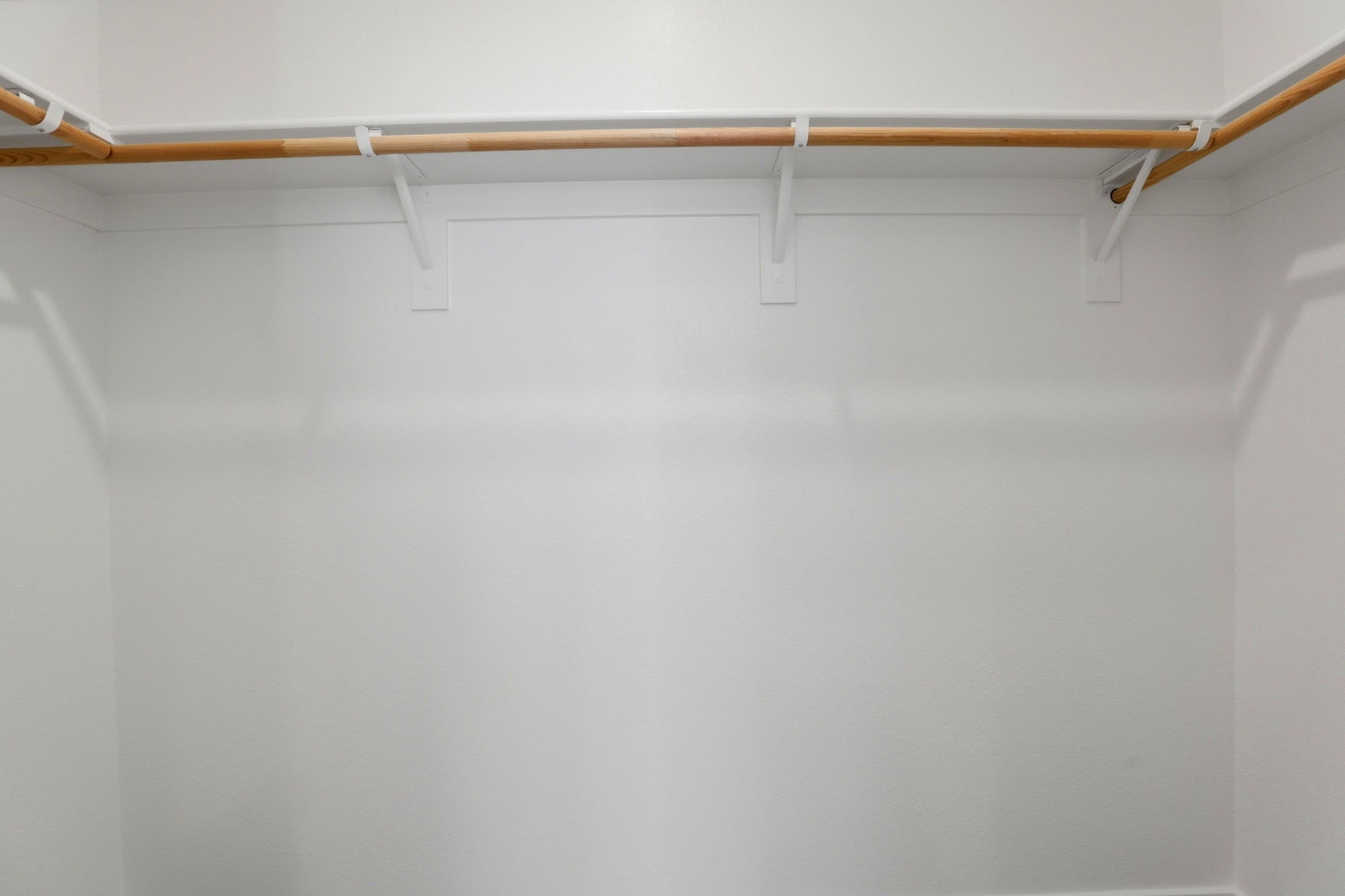 A white wall with a wooden pole.