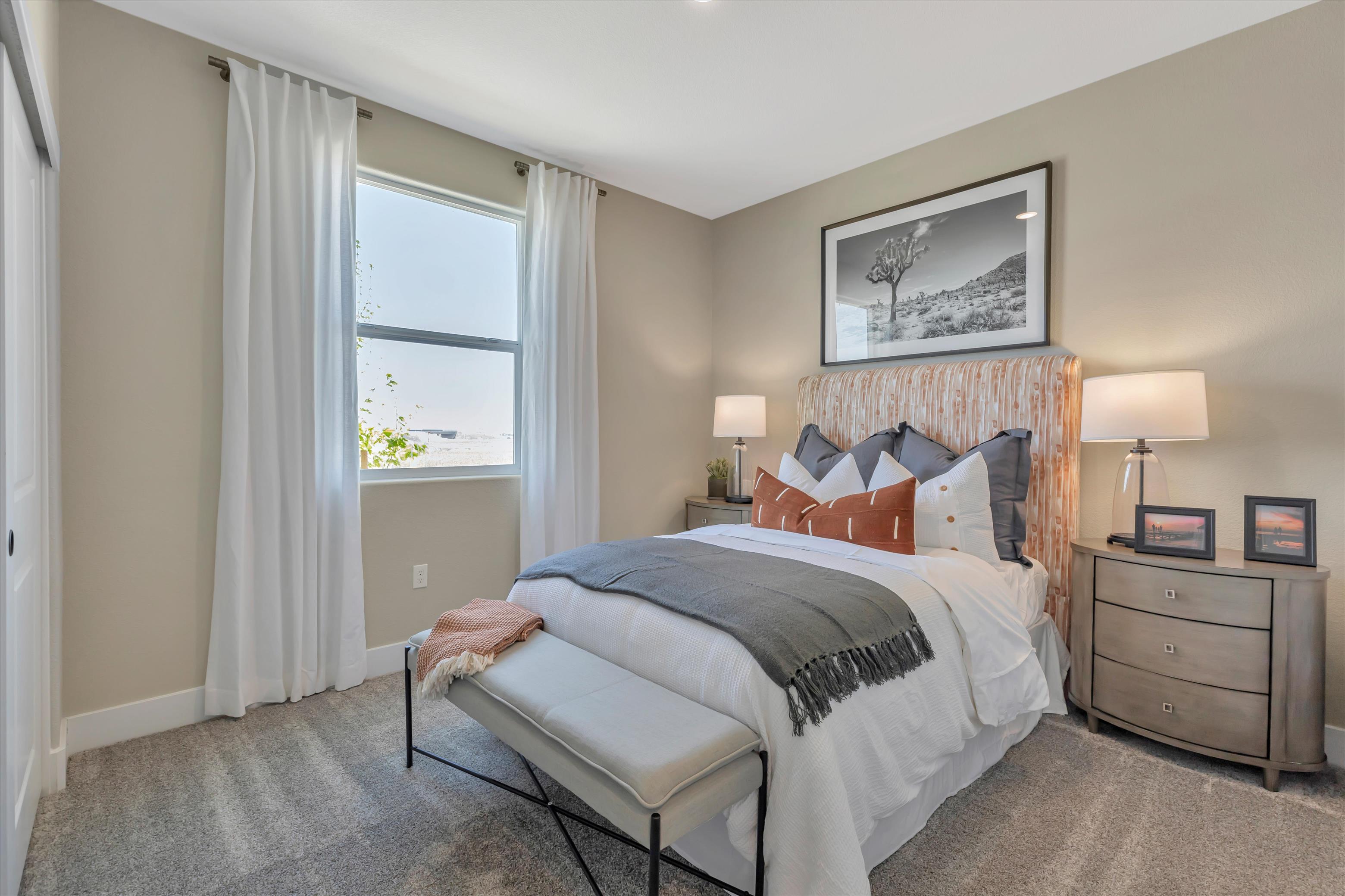 A bedroom with a bed and a bench.