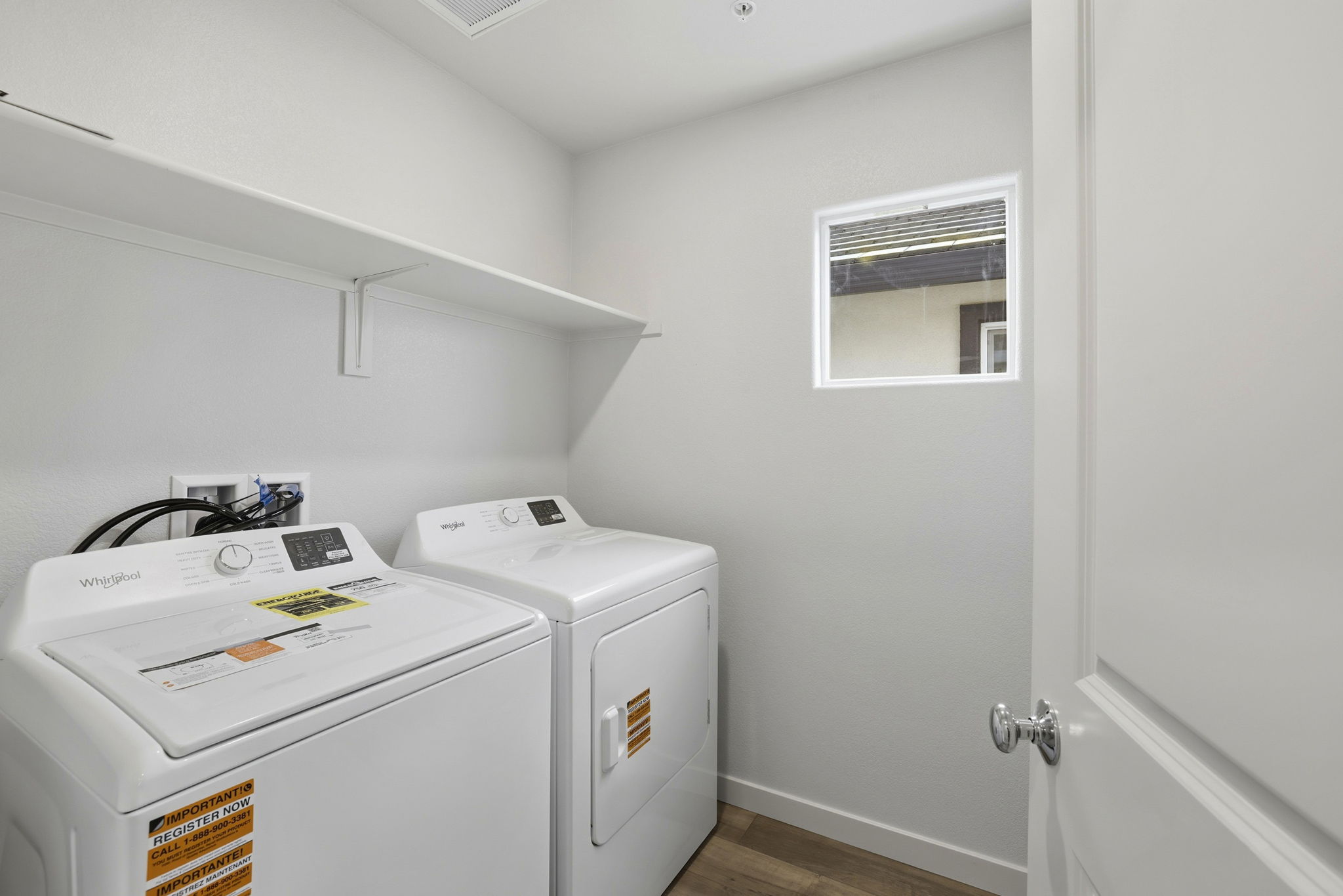 A white laundry room with a washer and dryer.