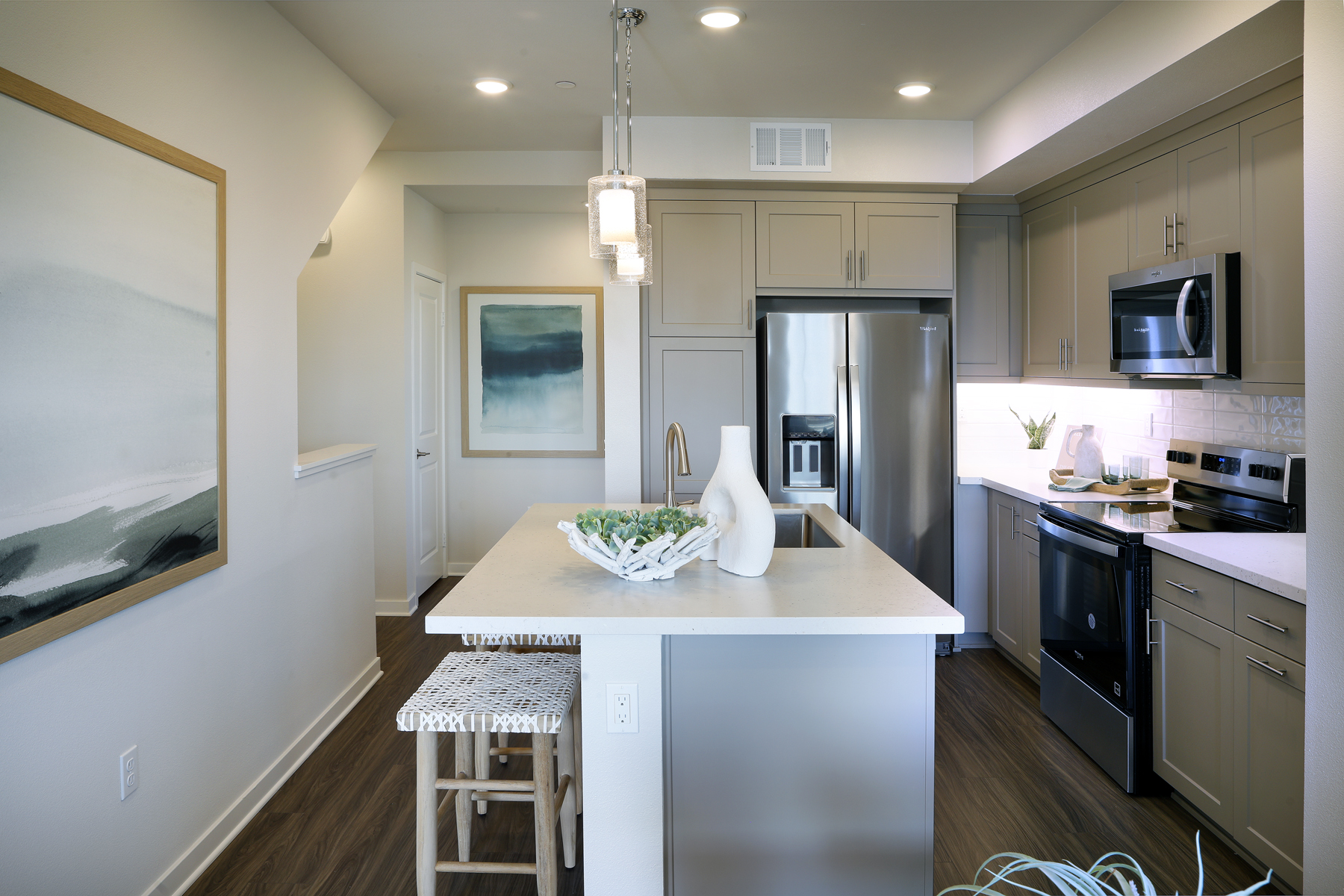 A kitchen with a bar stool and a table.