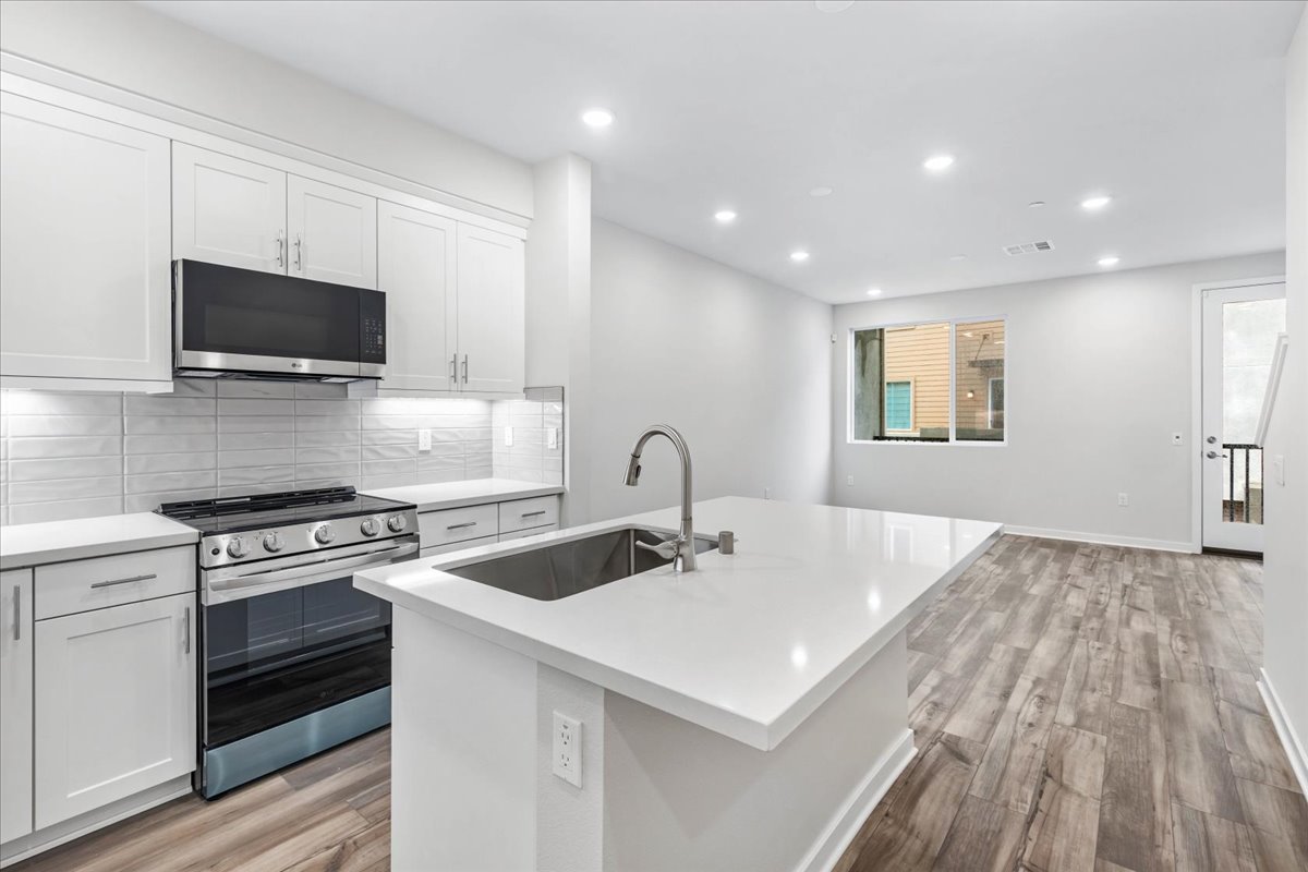 A kitchen with white cabinets.