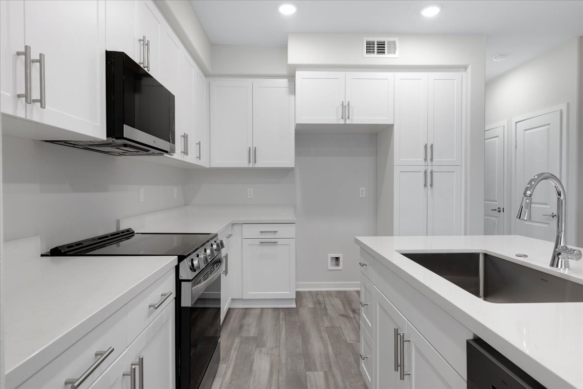 A kitchen with white cabinets.