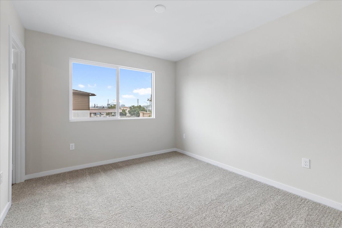 A room with a window and a white wall.