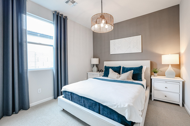 A bedroom with a bed and lamps.