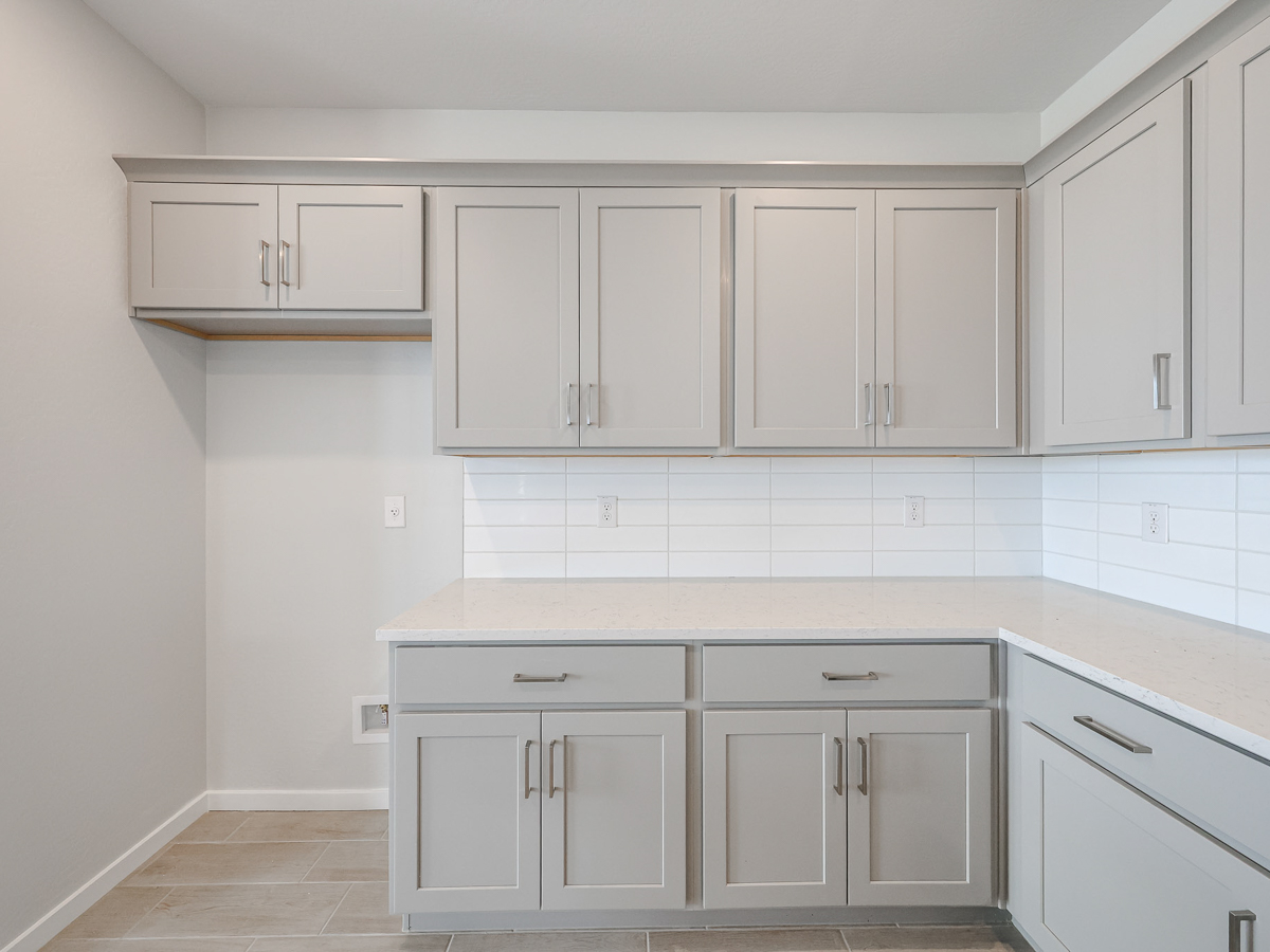 A kitchen with white cabinets.