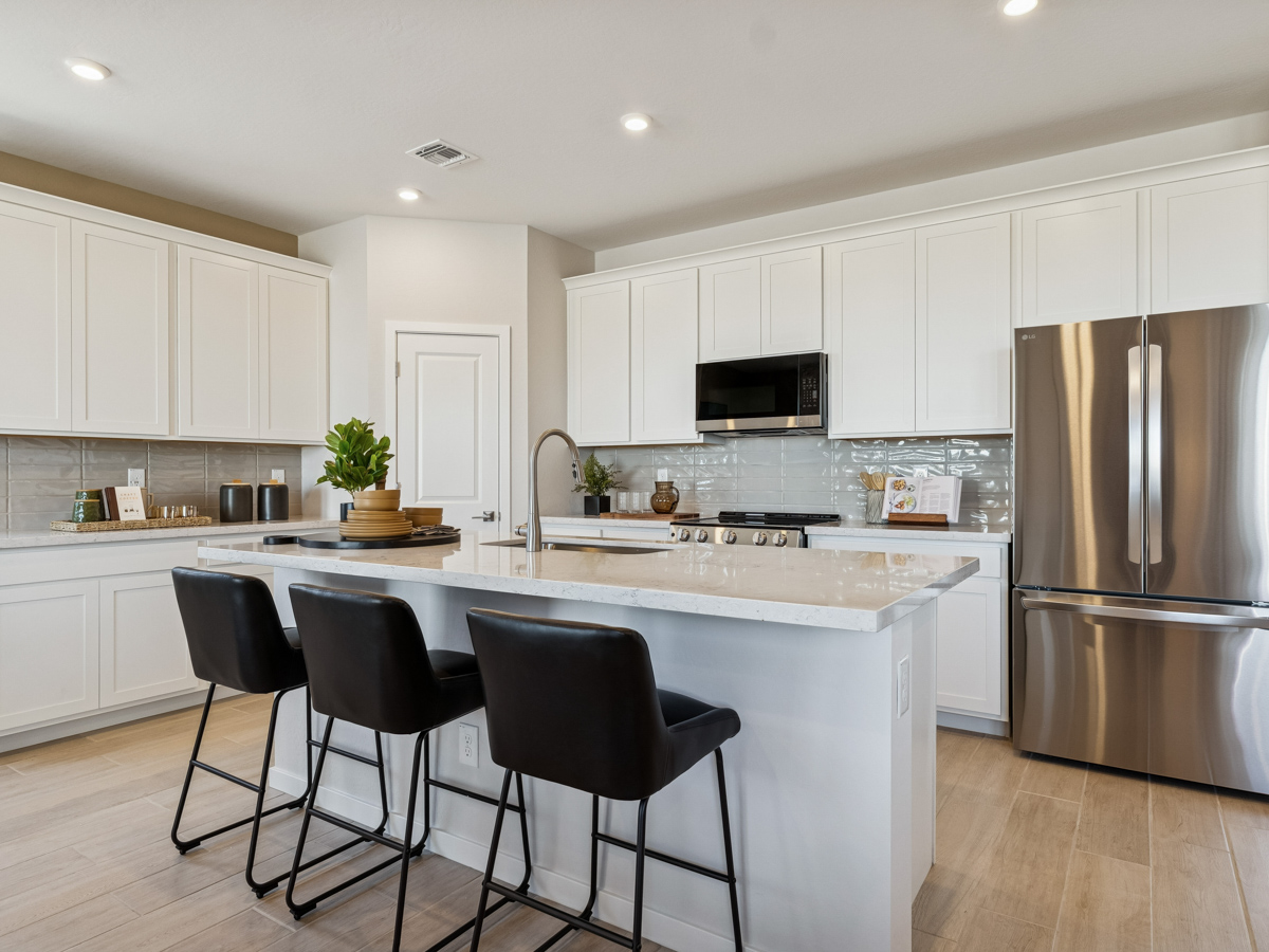 A kitchen with white cabinets.