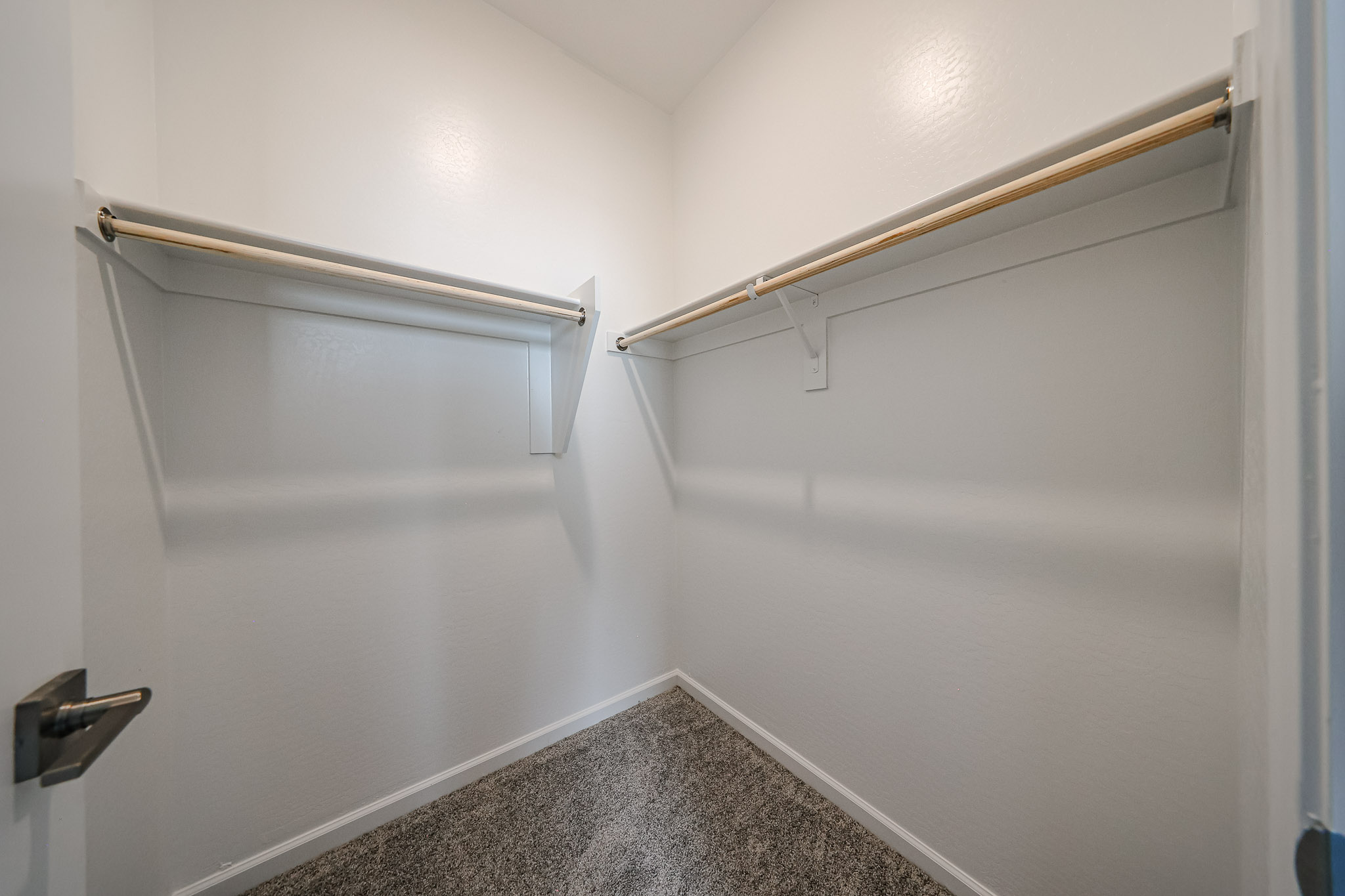 A white wall with a metal bar.