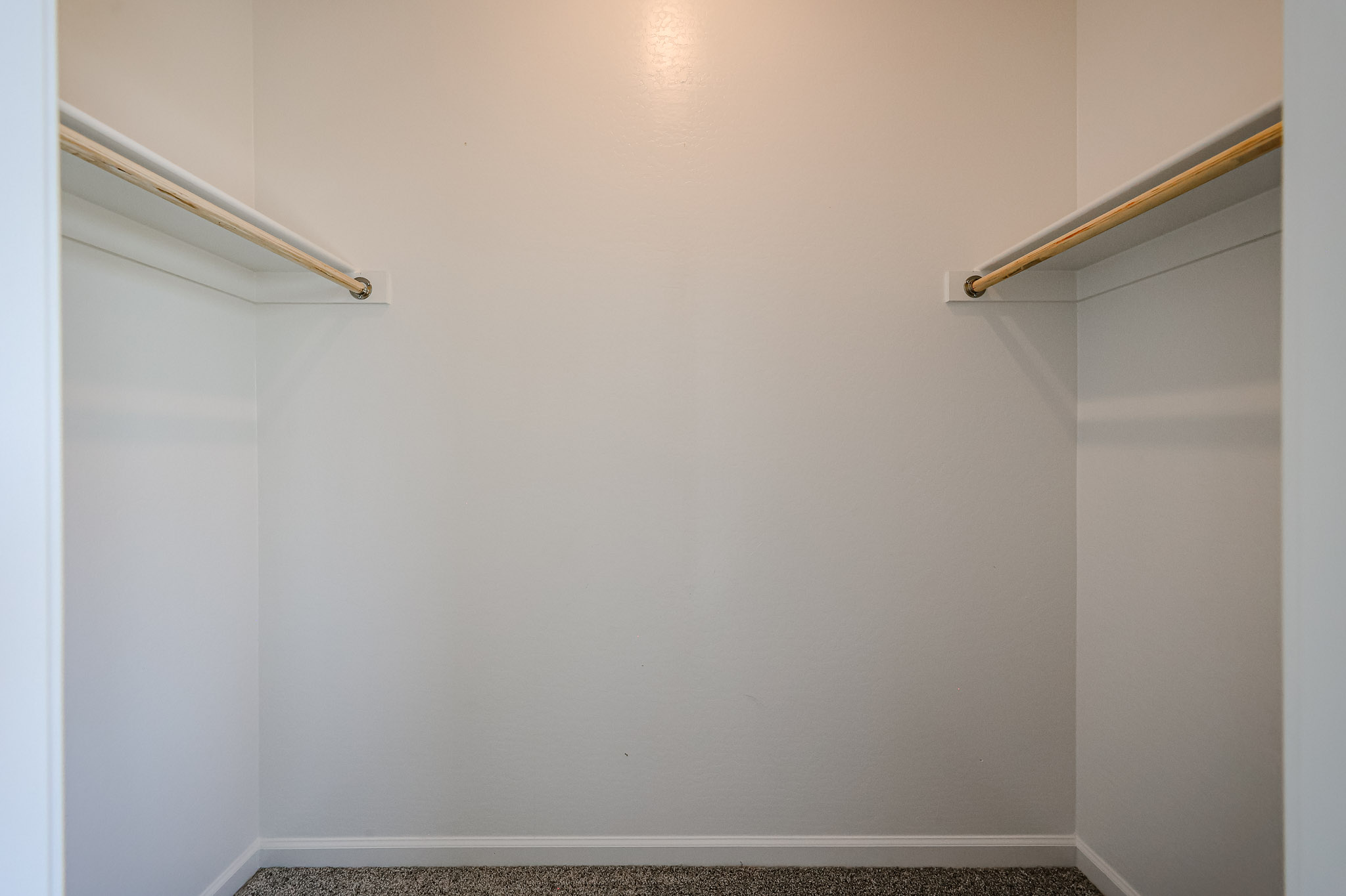 A white wall with a metal bar.