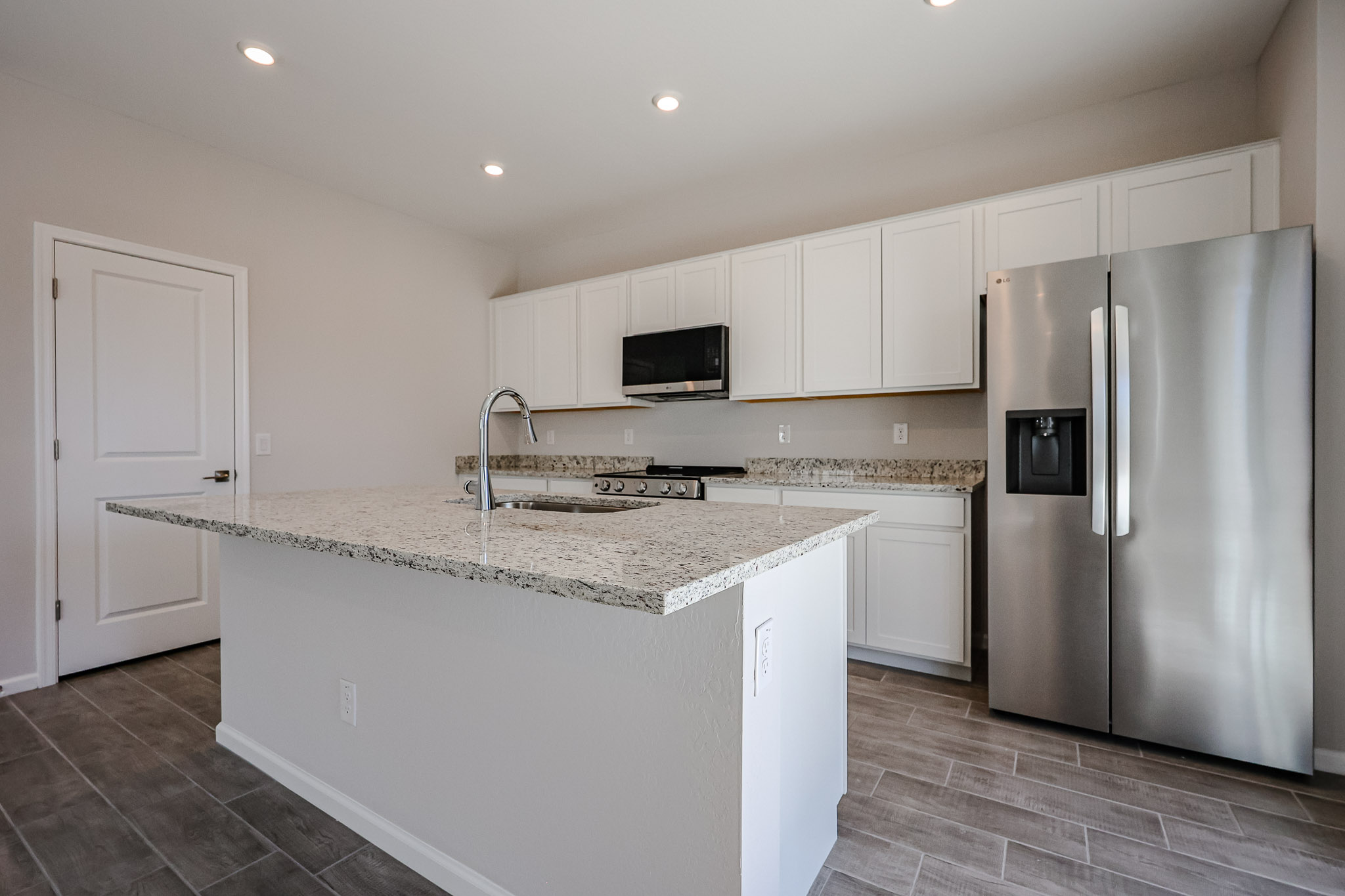 A kitchen with white cabinets.