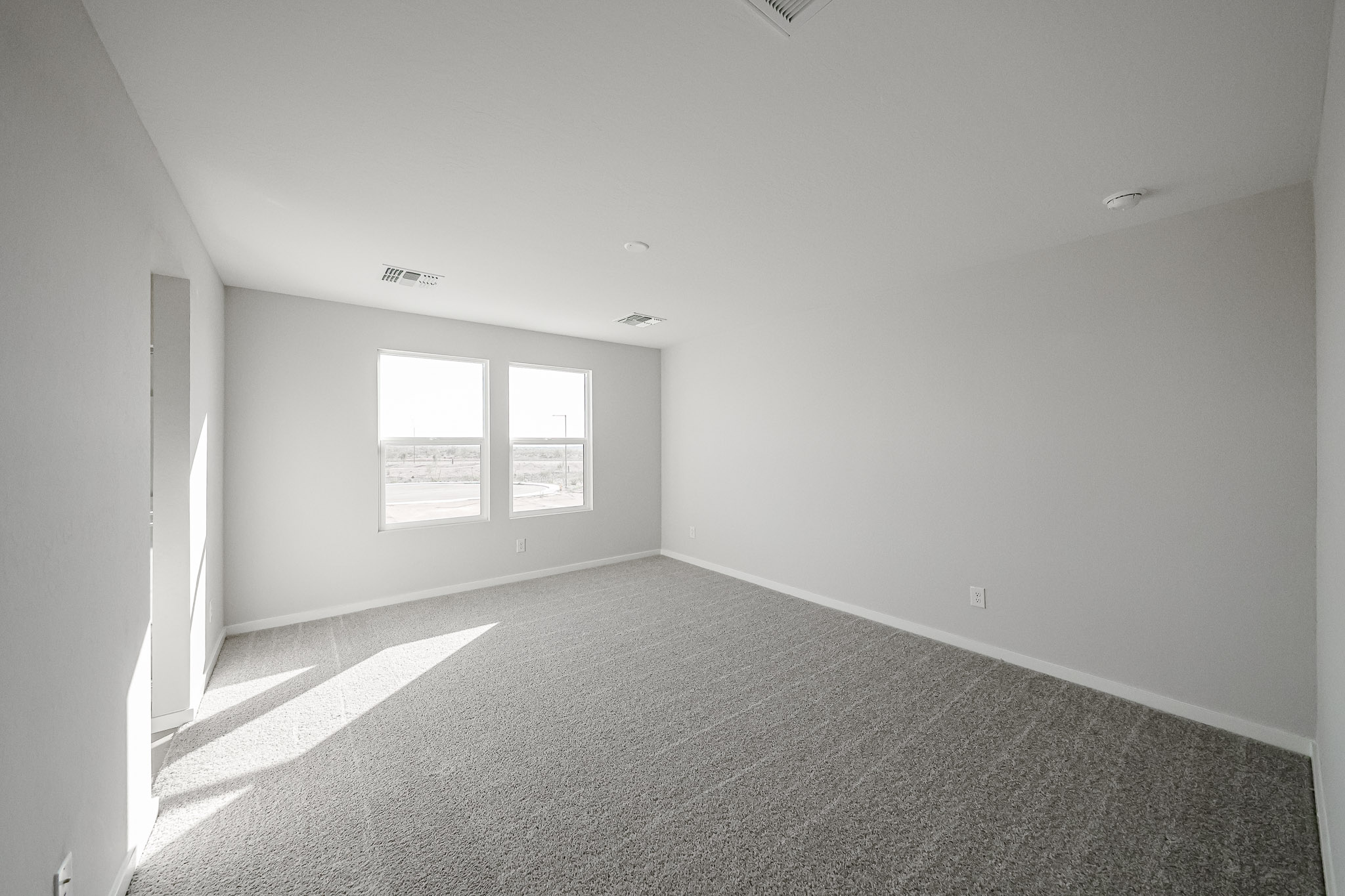A room with a carpet and windows.