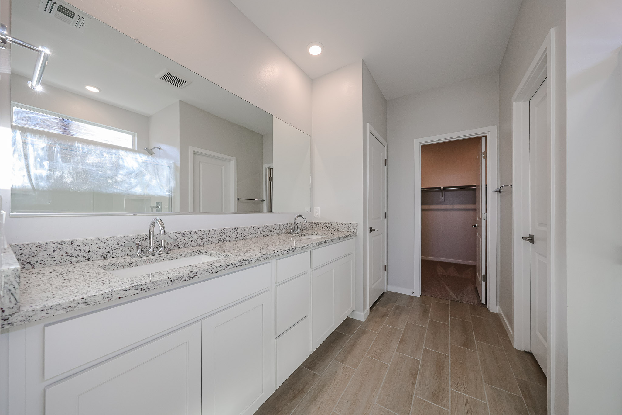 A bathroom with white cabinets.