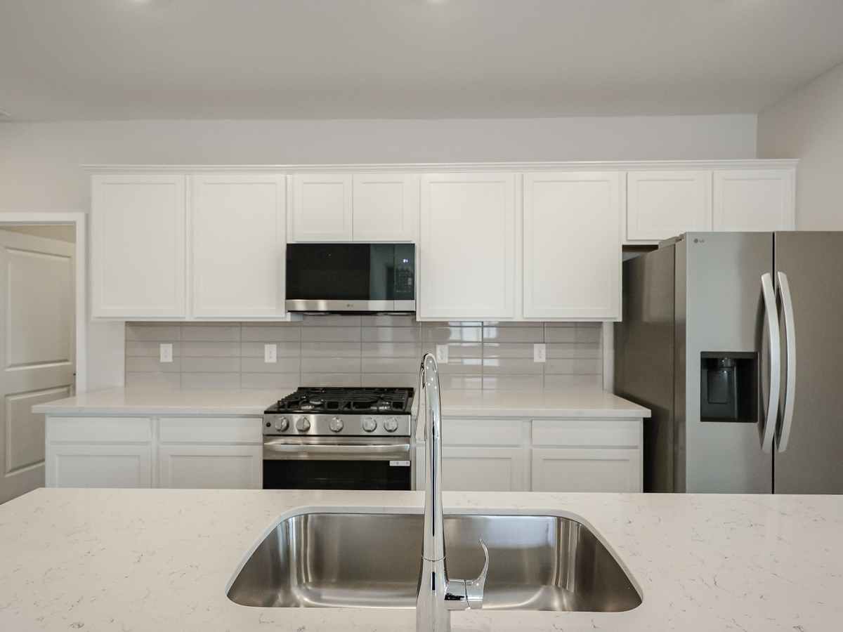 A kitchen with white cabinets.