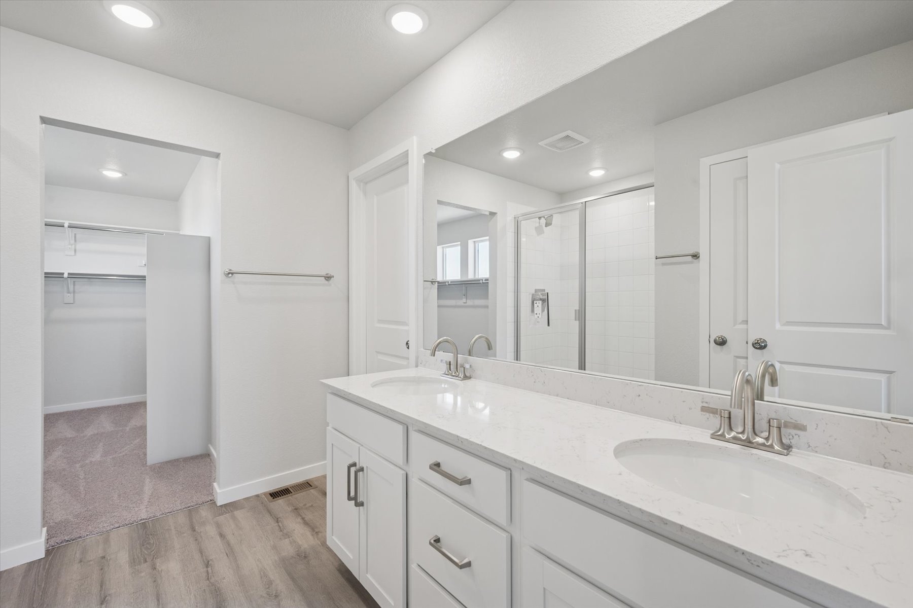 A bathroom with white cabinets.