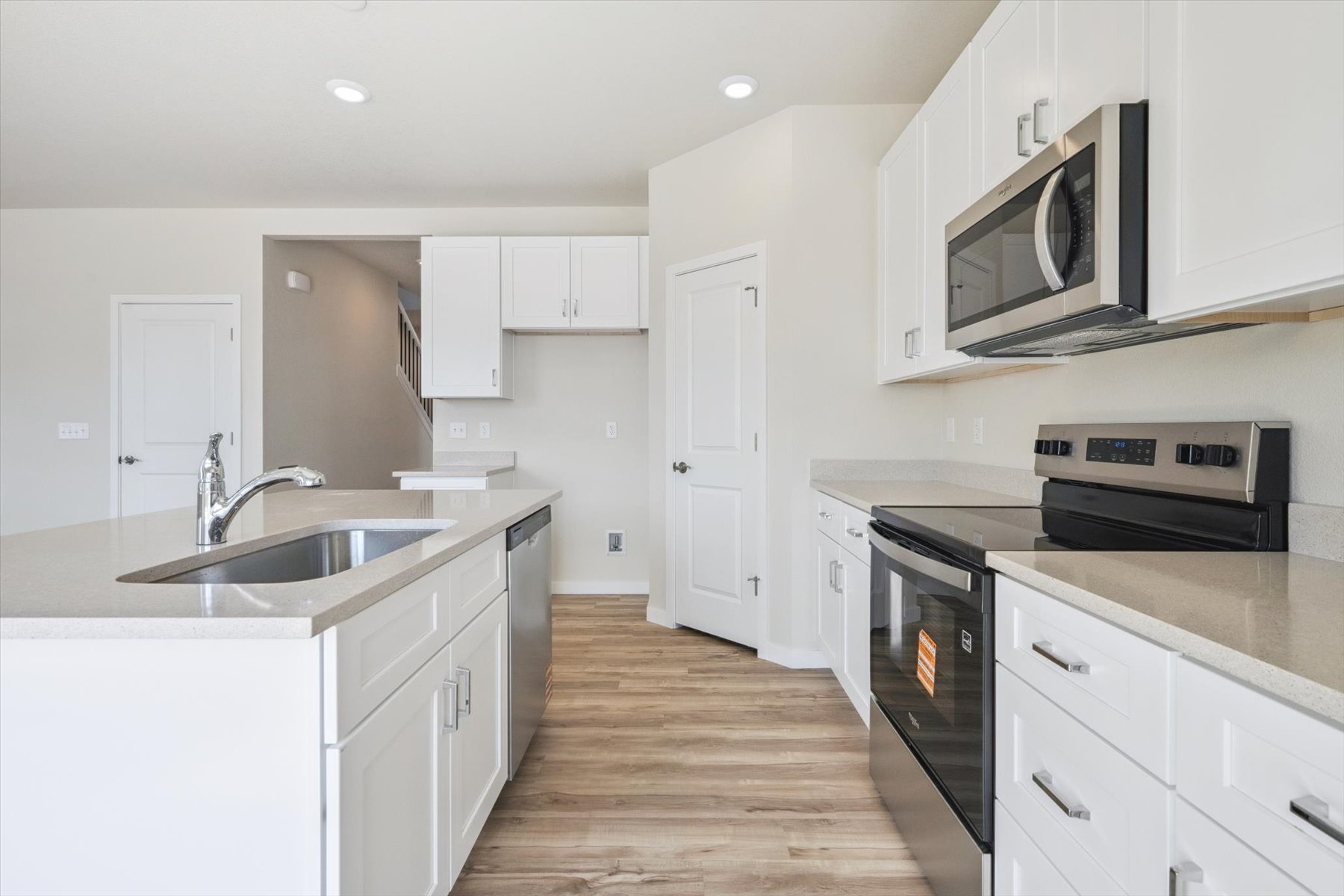 A kitchen with white cabinets.