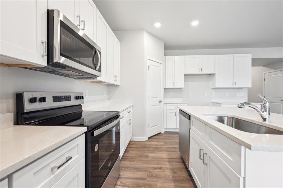 A kitchen with white cabinets.