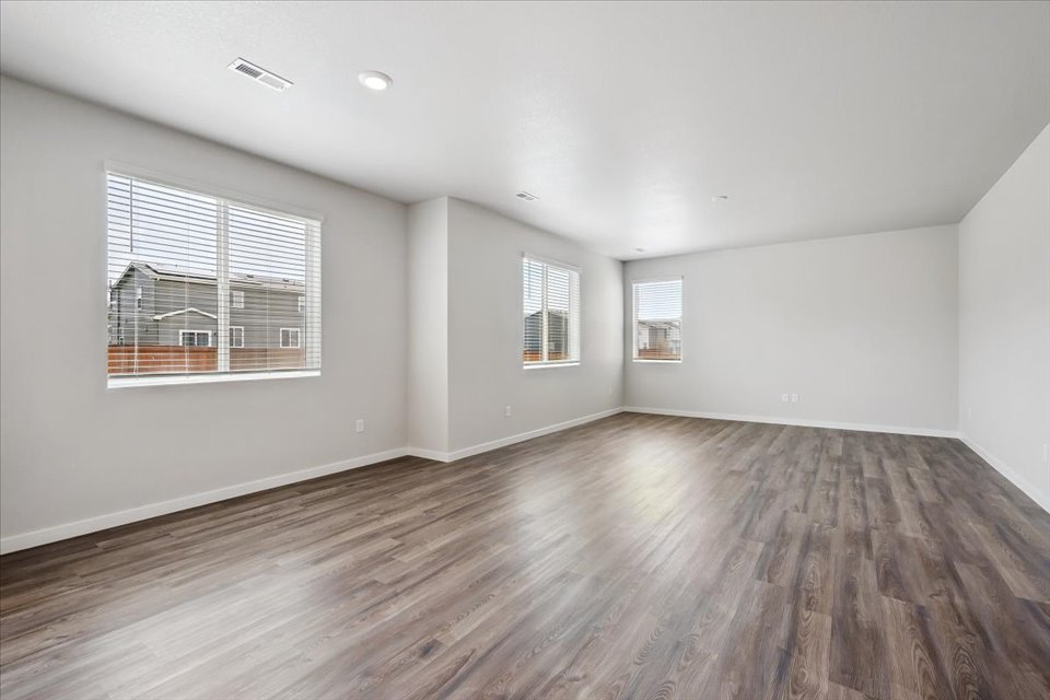 A room with a wood floor and windows.
