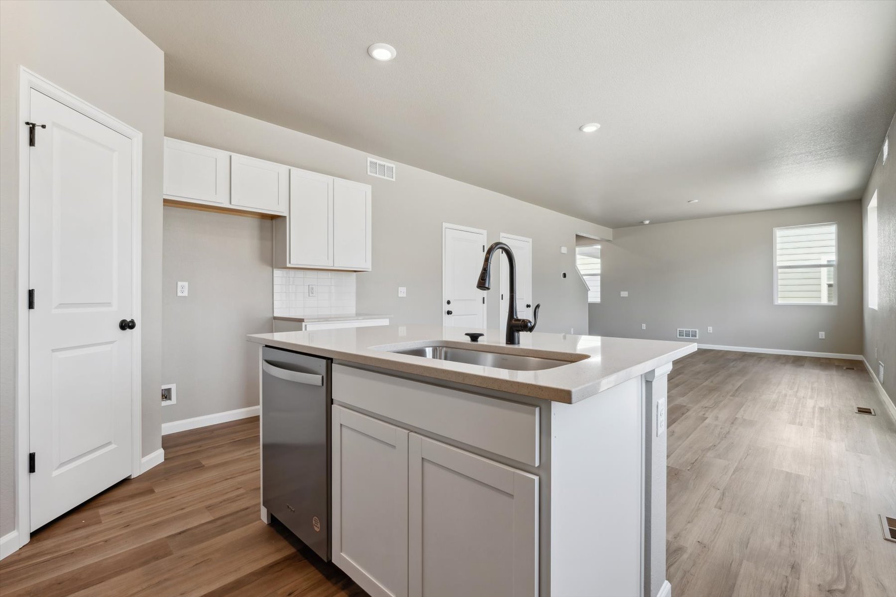 A kitchen with white cabinets.