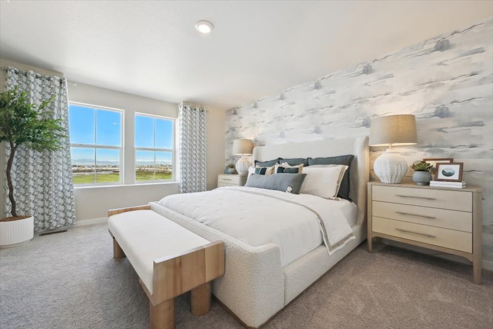 A bedroom with a bed and a bench.