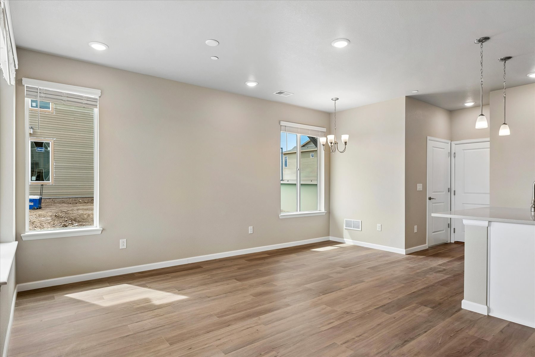 A room with a wood floor and white cabinets.