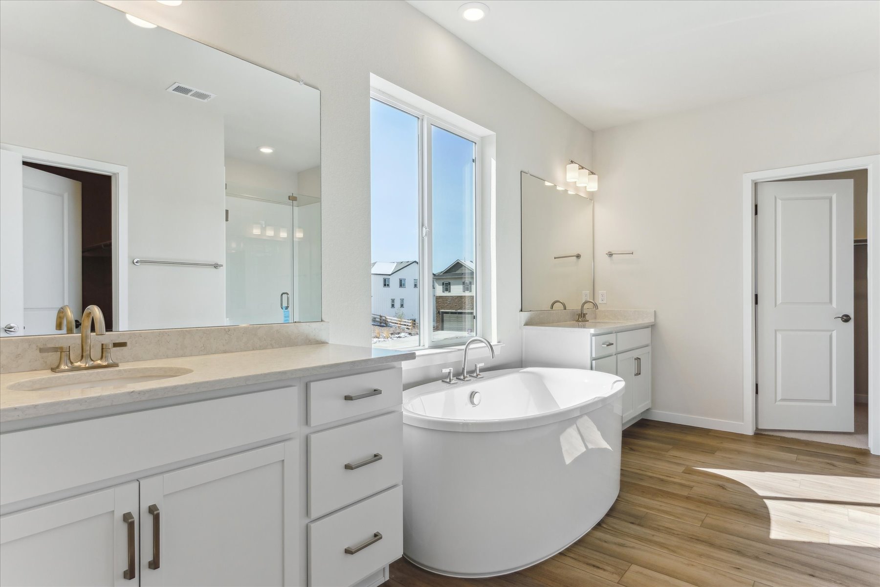 A bathroom with a tub sink and mirror.