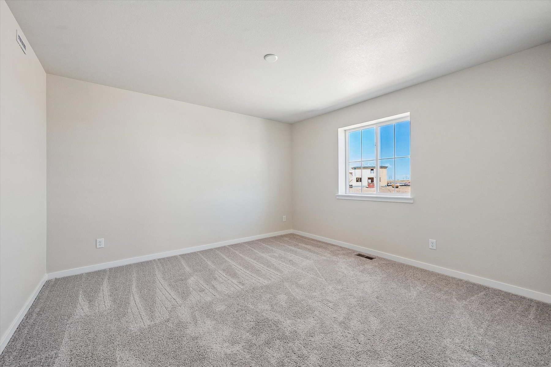 A room with a window and carpet.