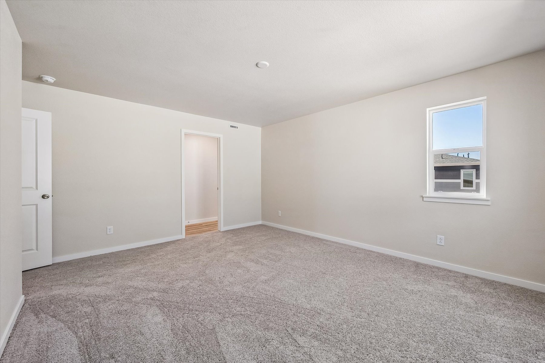 A room with a carpet and a window.