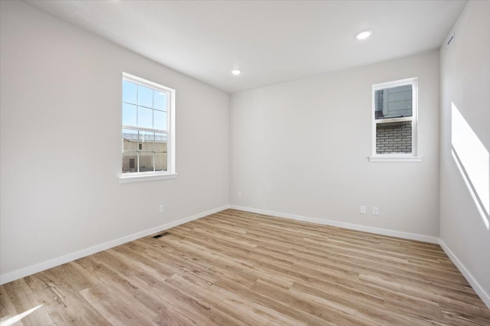 A room with a wood floor and windows.