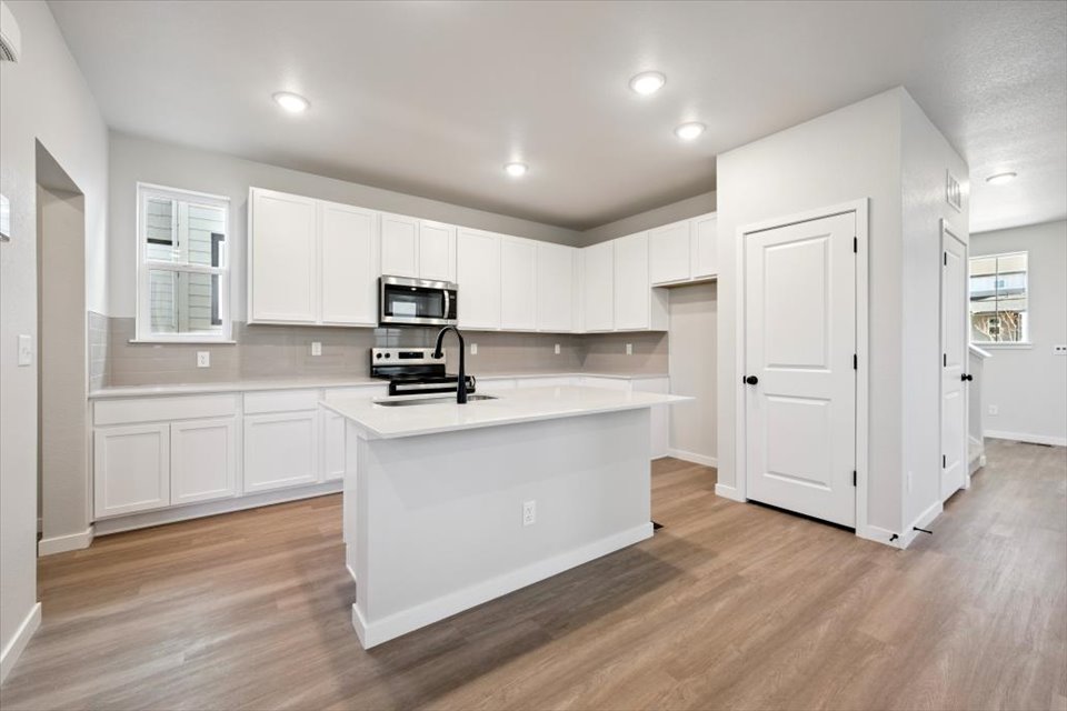 A kitchen with white cabinets.