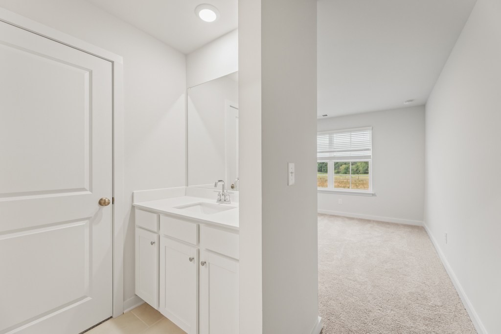 A bathroom with white cabinets.