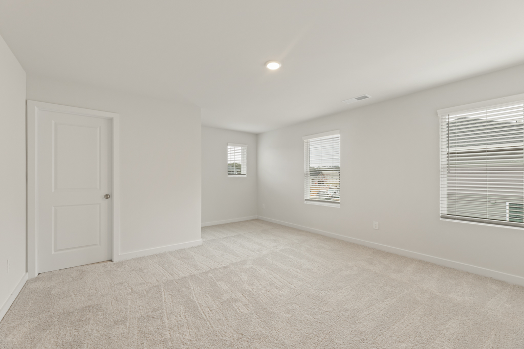 A room with a carpet and windows.