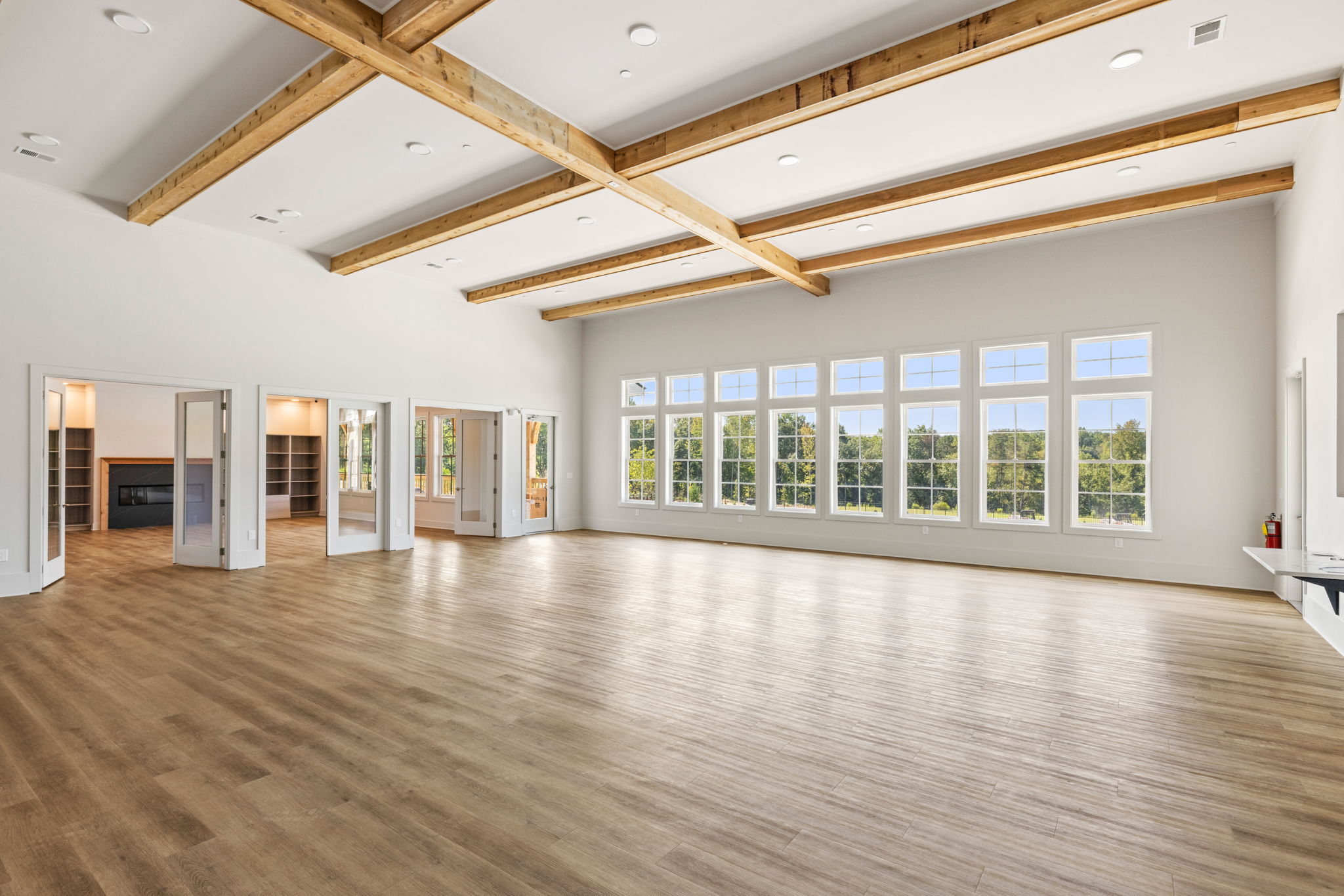 A large empty room with a wood floor and a large window.