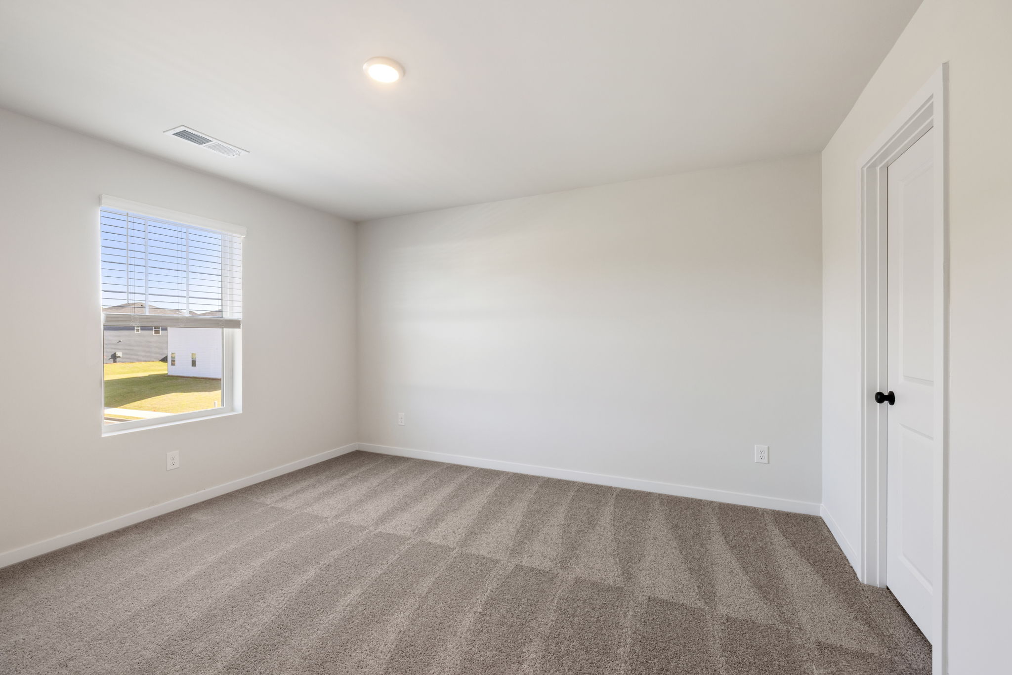 A room with a window and a carpet.
