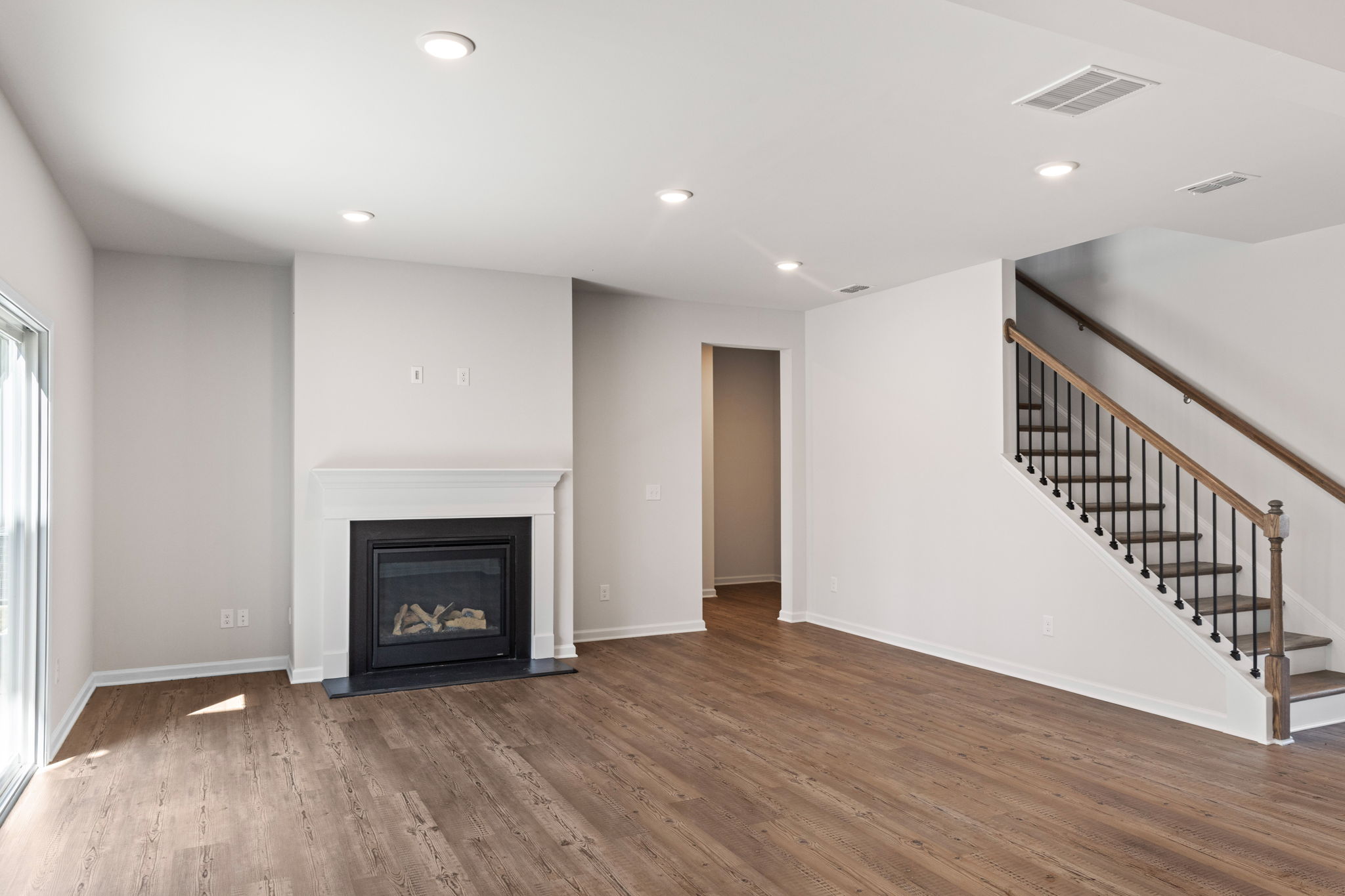 A room with a fireplace and a wood floor.