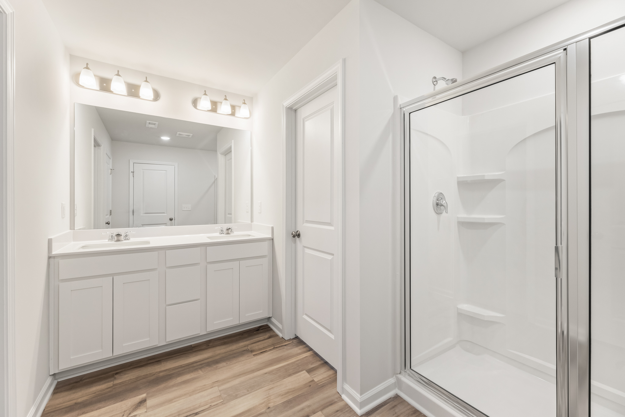 A bathroom with white cabinets.