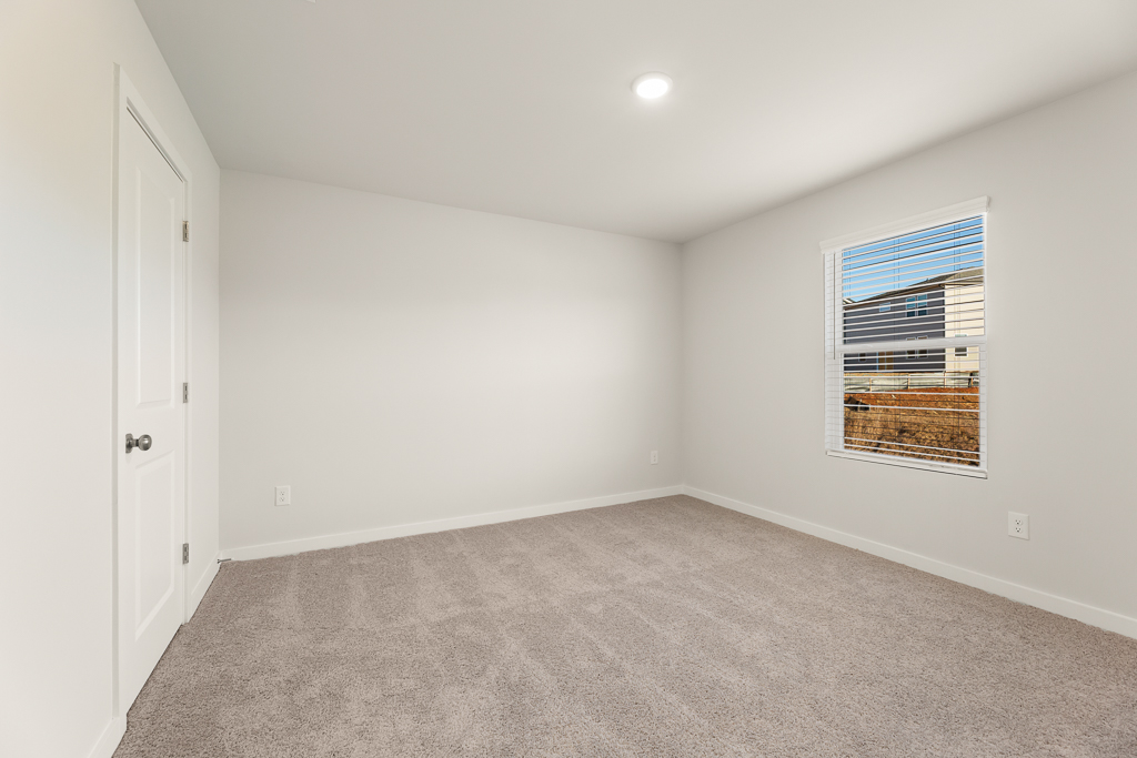 A room with a window and a carpet.