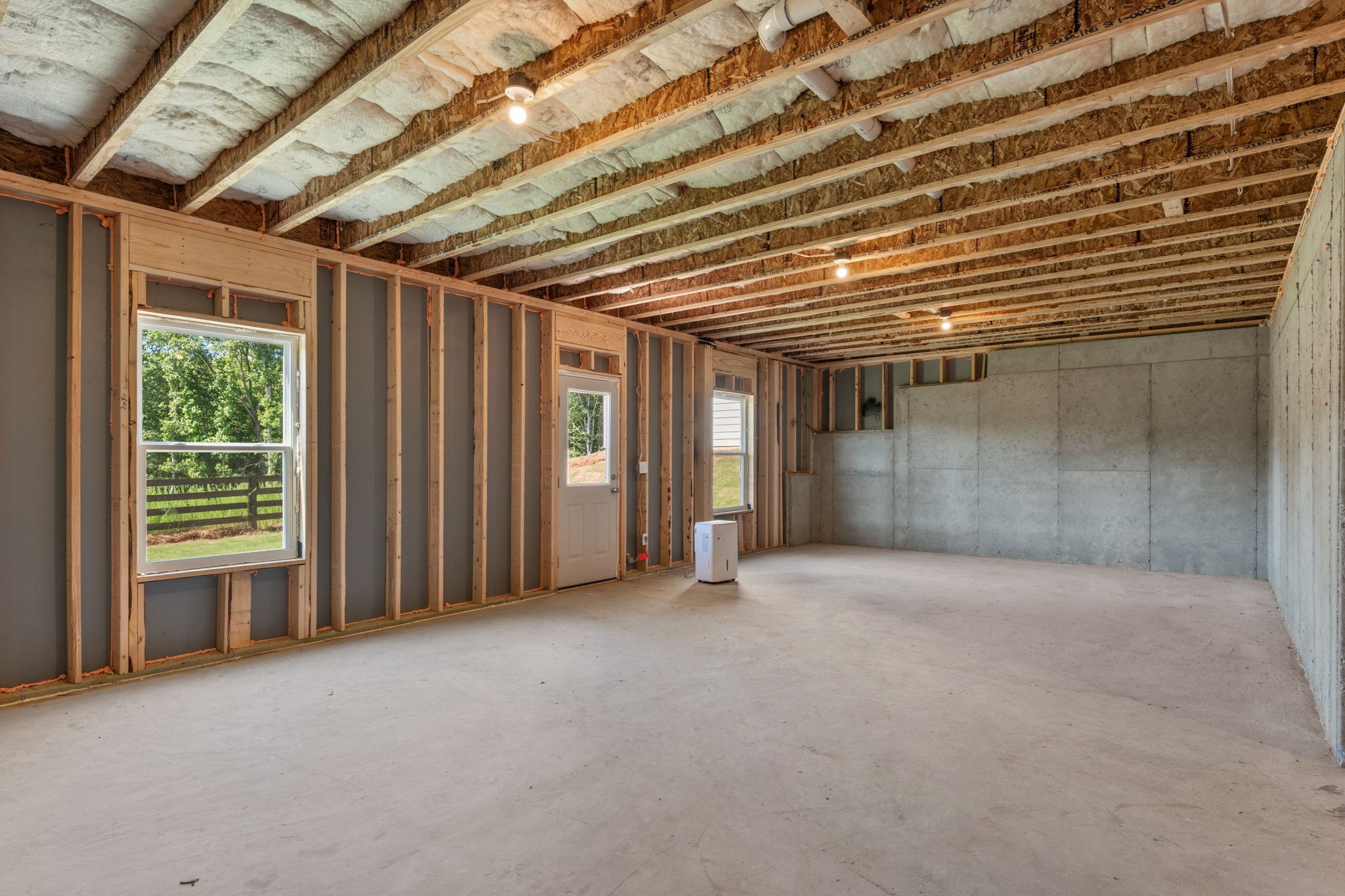 A room with a concrete floor and windows.