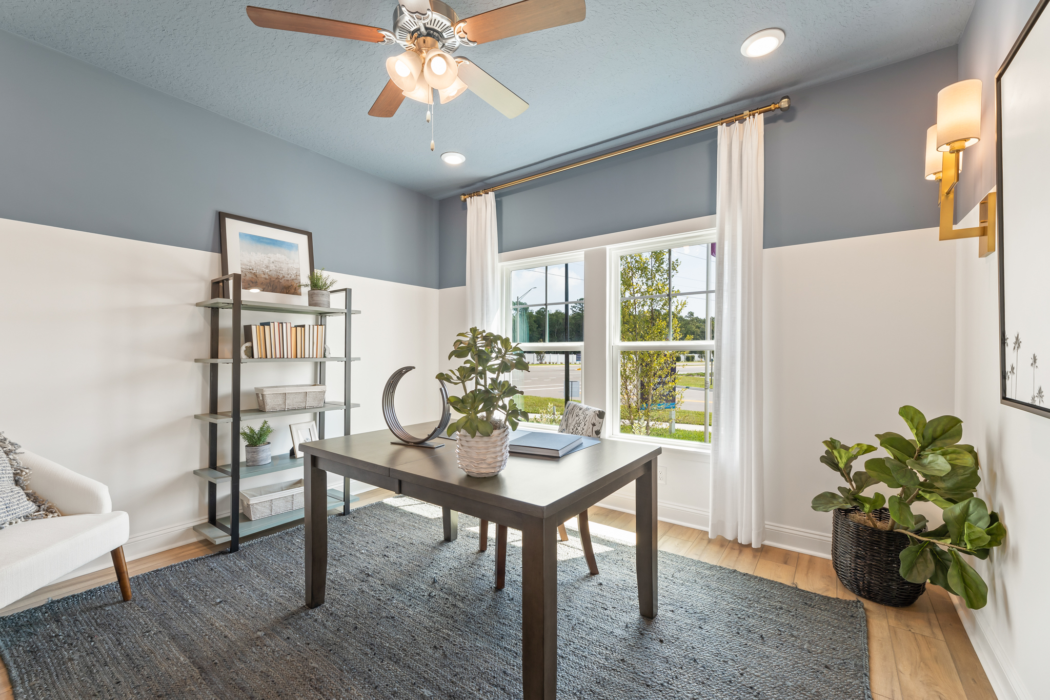 A living room with a table and a fan.
