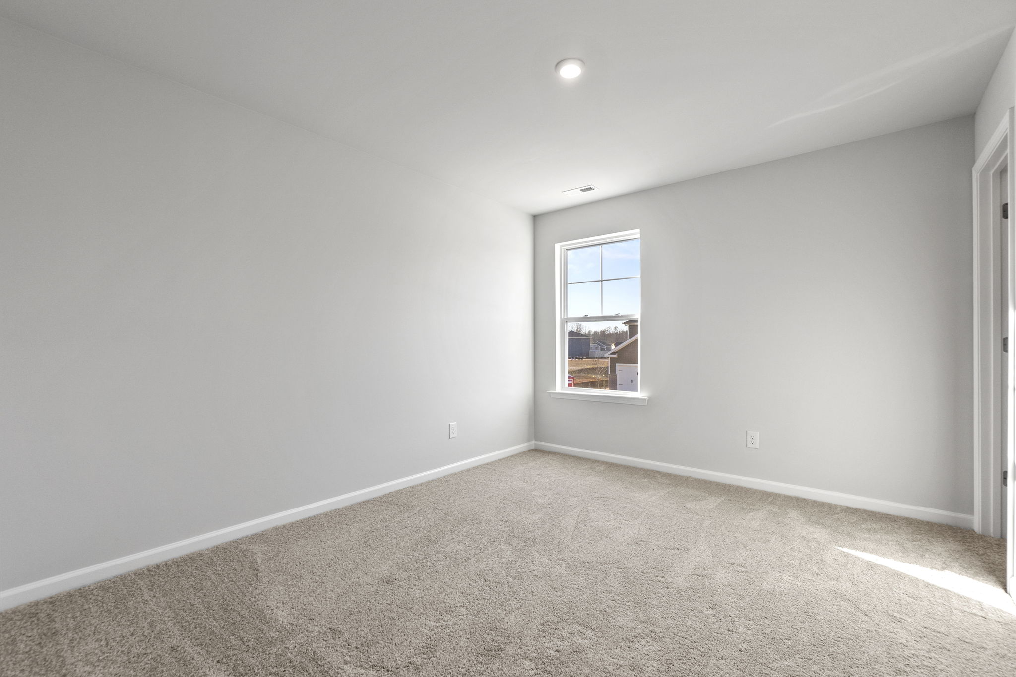 A room with a window and carpet.
