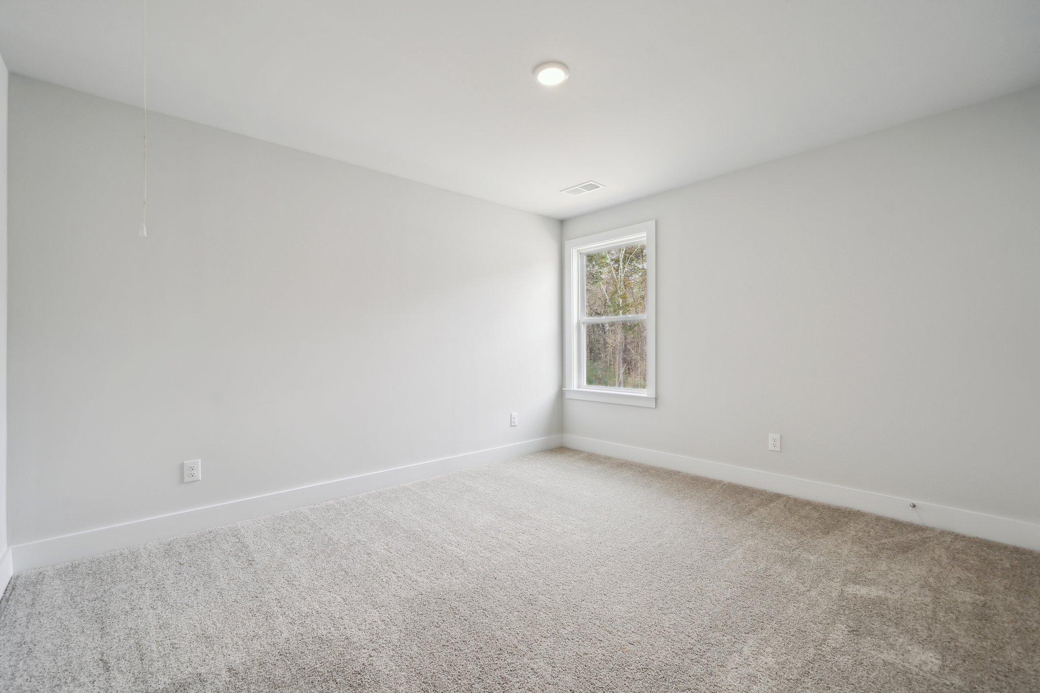 A room with a window and carpet.