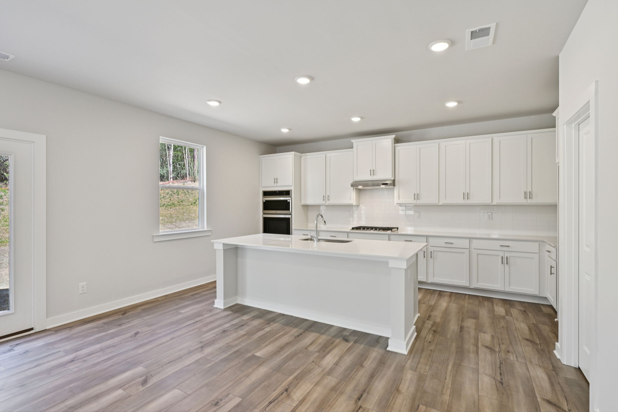 A kitchen with white cabinets.