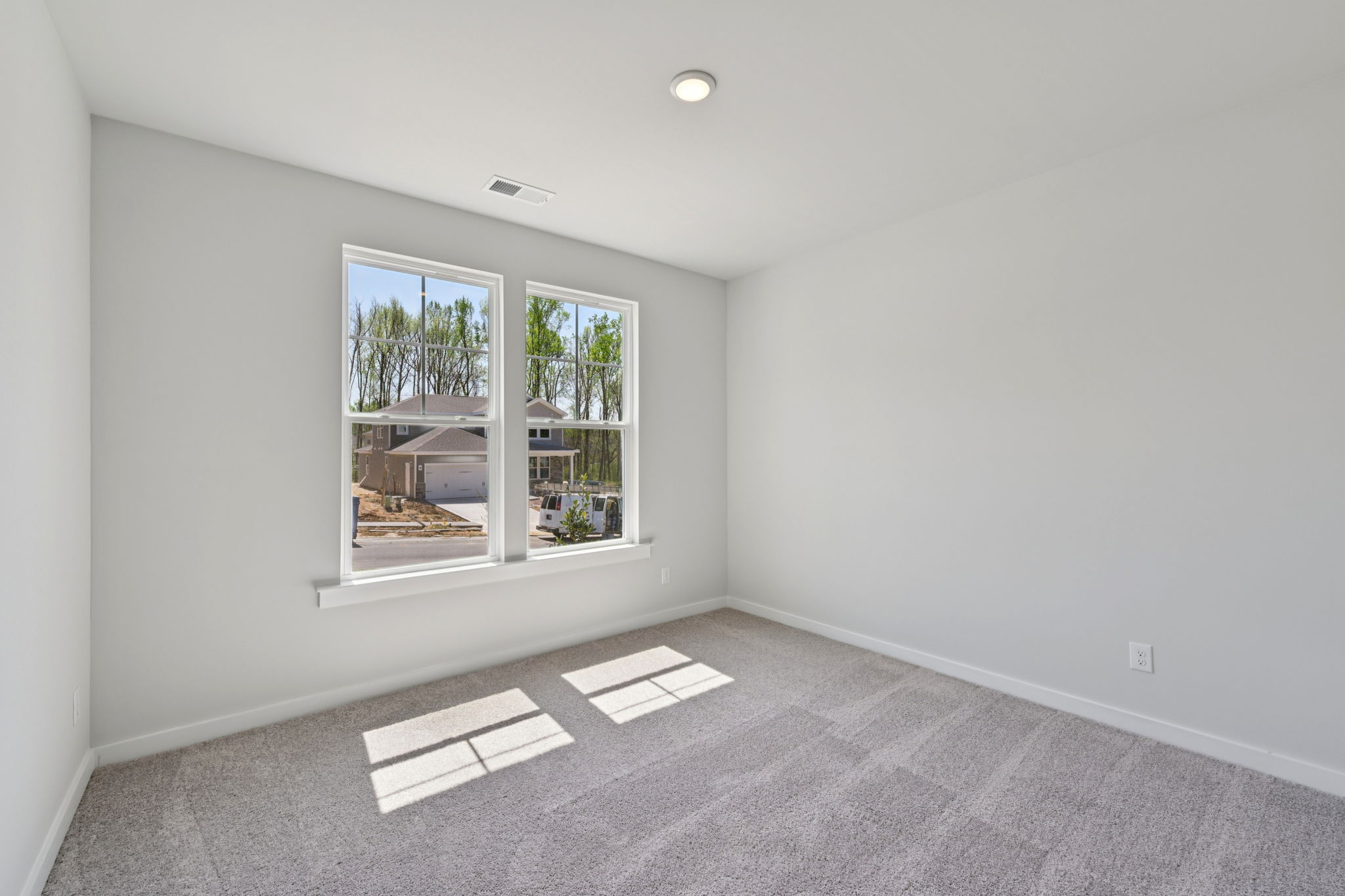 A room with a window and a rug.