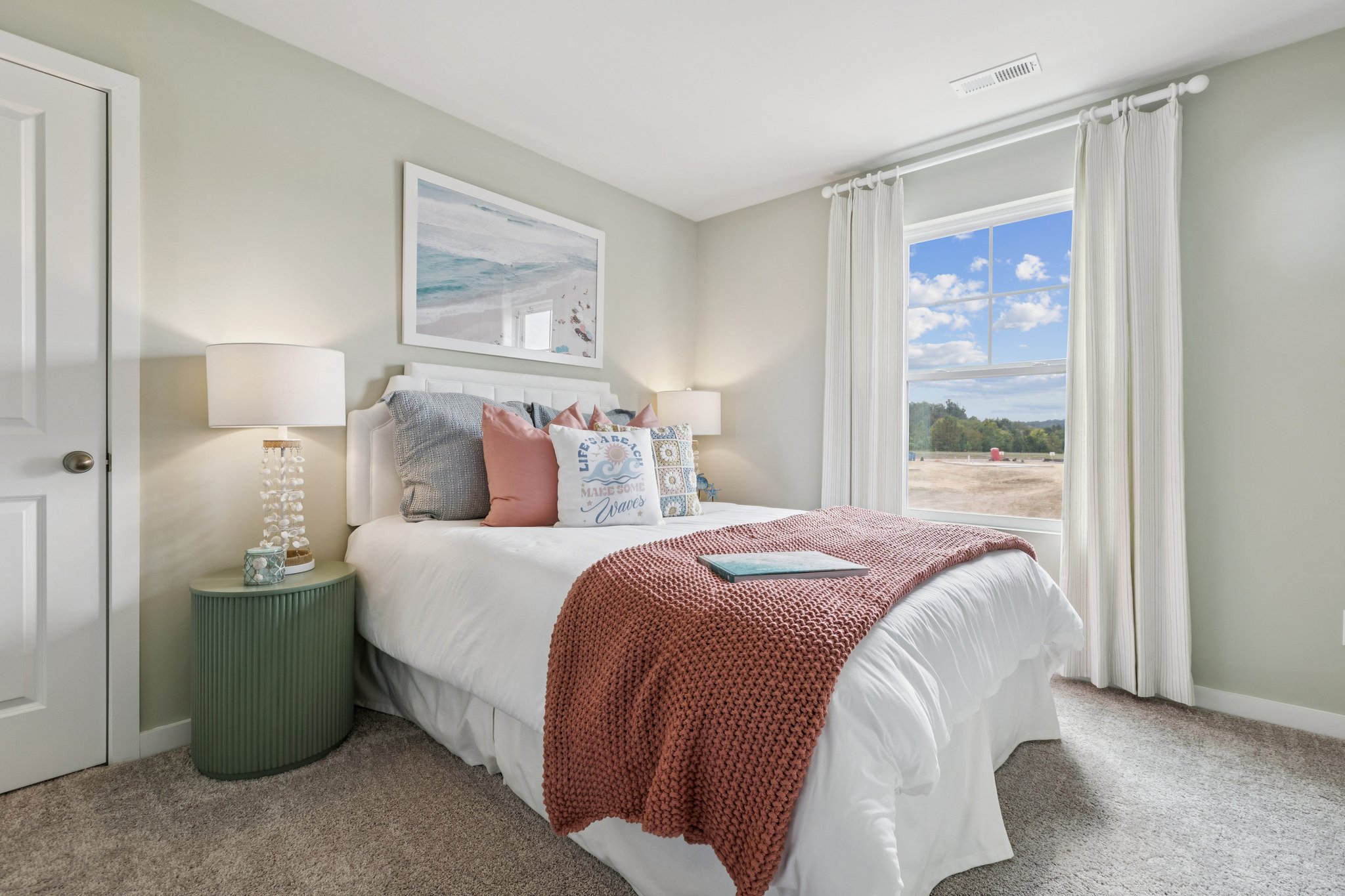 A bedroom with a large window.