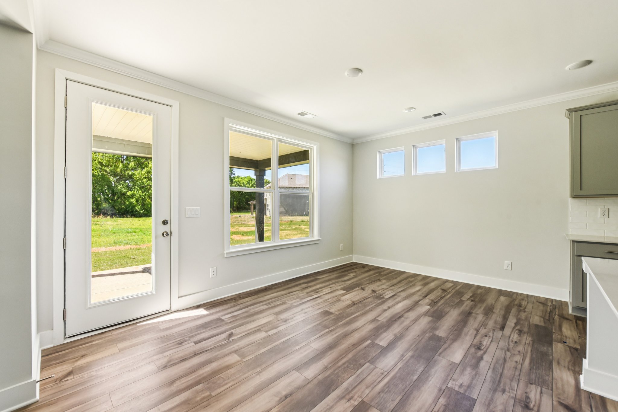 A room with a wood floor and windows.