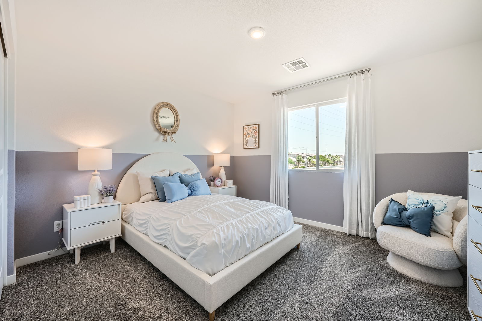 A bedroom with a bed and a chair.